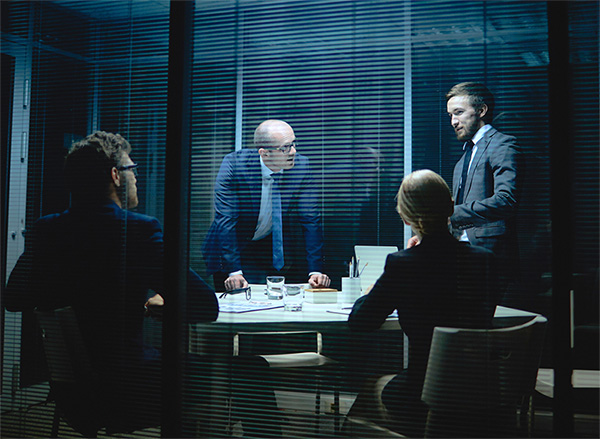 Photo of four business people at a meeting table