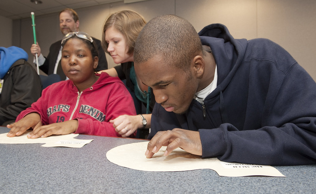 Teachers working with a visually impaired students