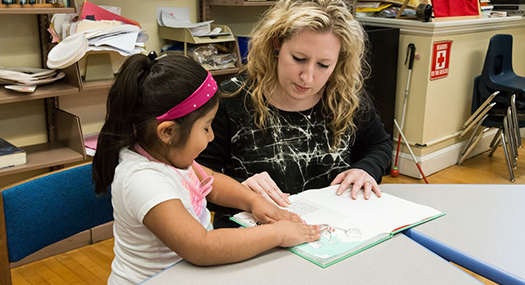 A teacher working with a visually impaired student